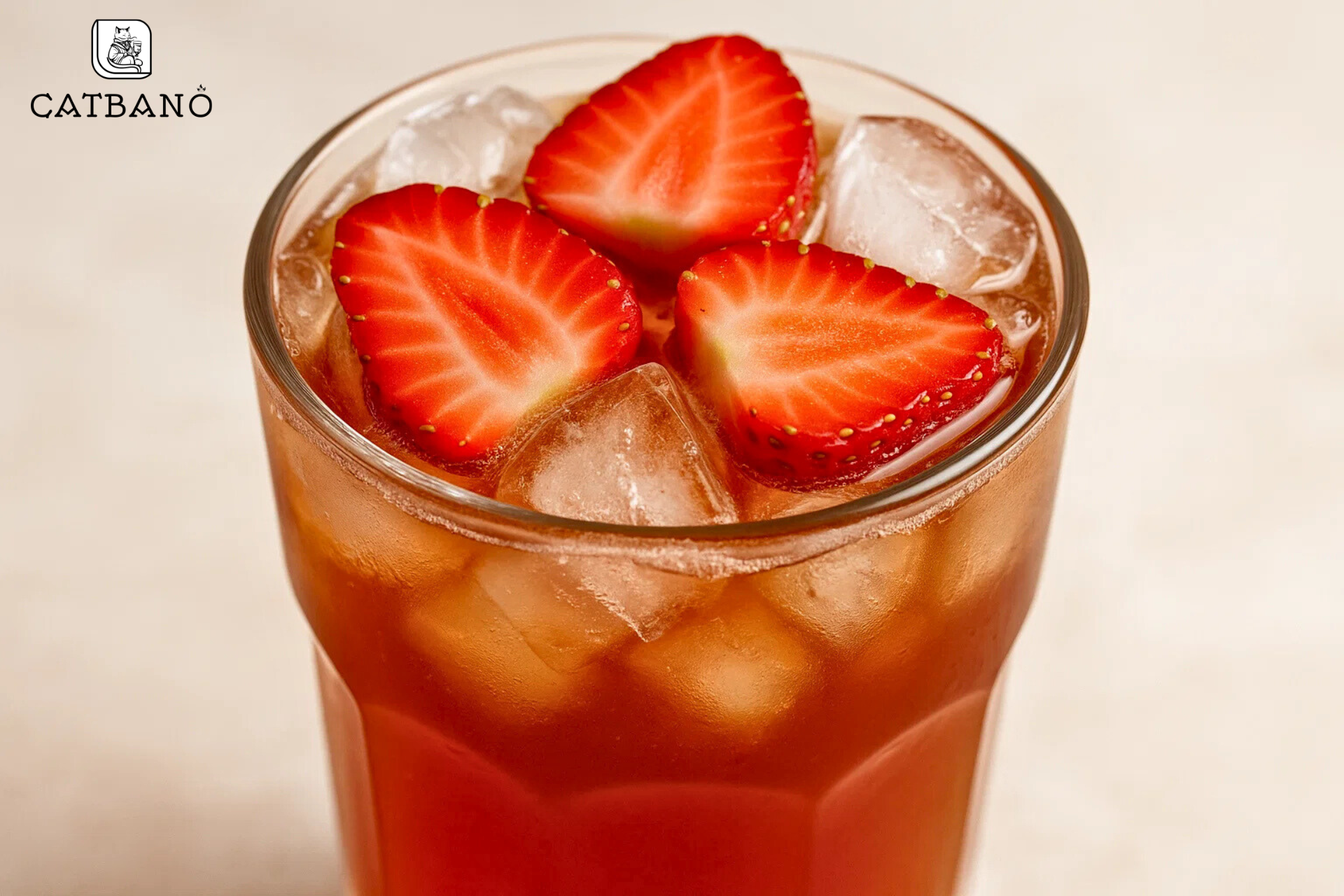 Hình ảnh cận cảnh ly trà có topping dâu tươi nổi bật, kèm đá viên mát lạnh.