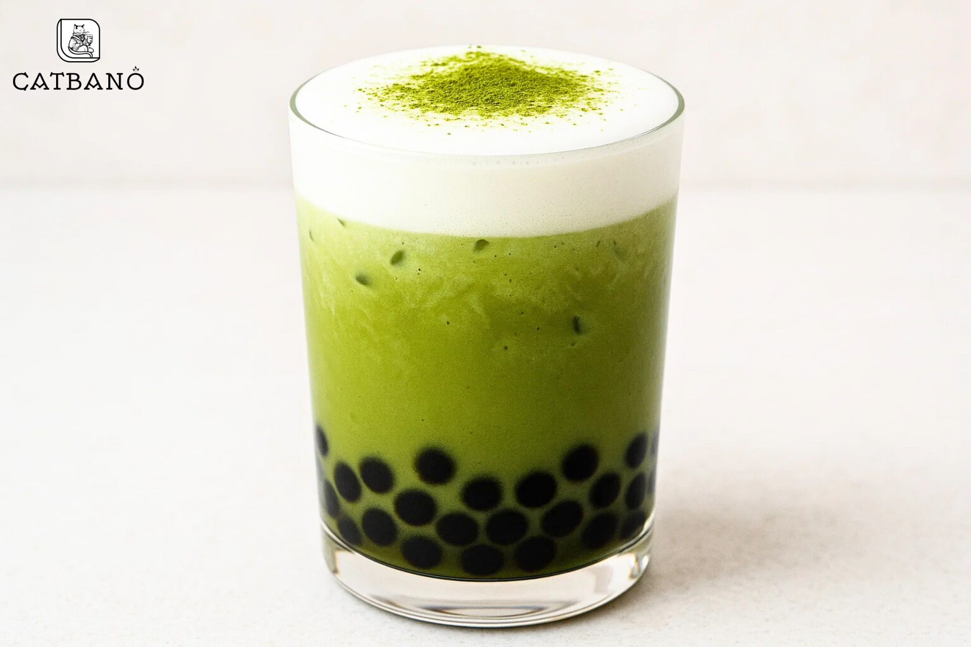 Matcha Oolong latte trân châu trong ly trong suốt, nhìn rõ lớp bọt sữa và topping.